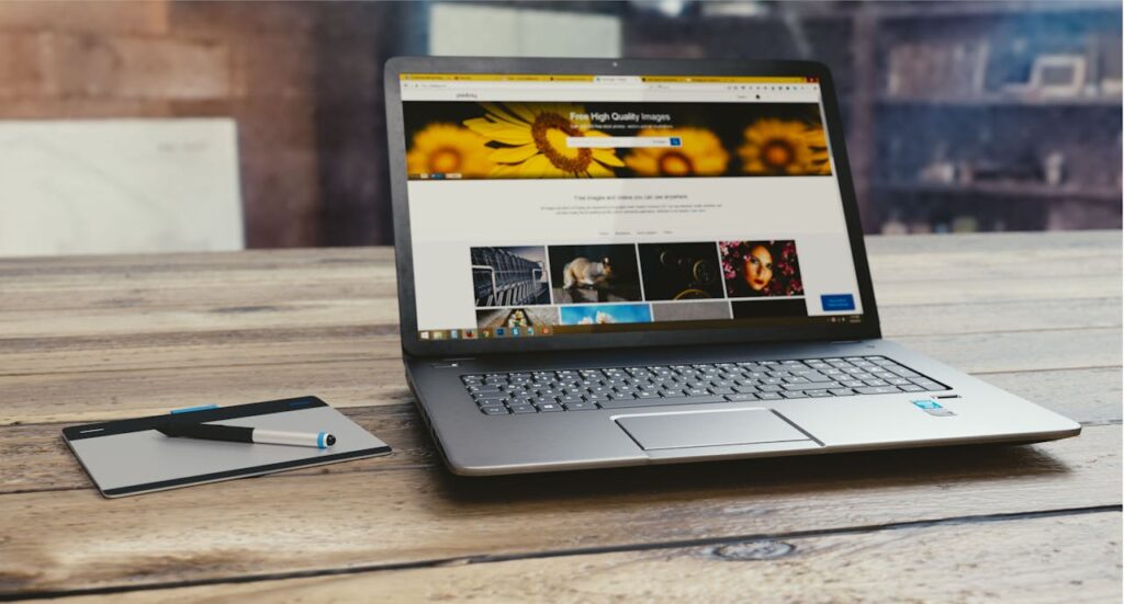 pexels-photo-109371 Laptop with open webpage on wooden desk, accompanied by tablet and pen, representing digital work setup. Kodulehe tegemine, veebilehe tegemine